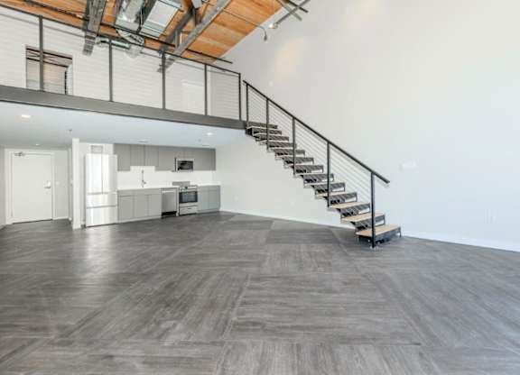 A wooden staircase with metal railings leads up to a second floor.