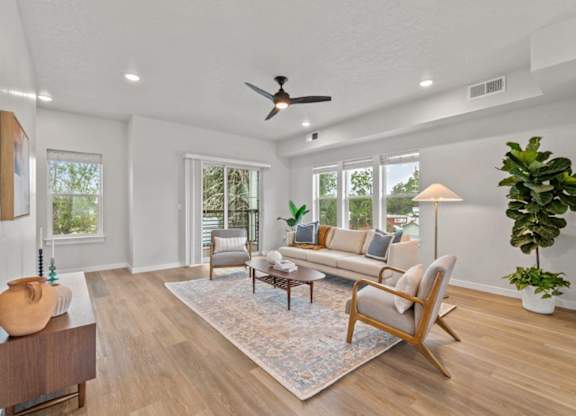 A living room with a large rug and a wooden floor.