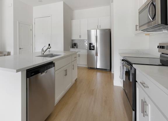A modern kitchen with white cabinets and stainless steel appliances.at Aerie La Cholla, Tucson Arizona