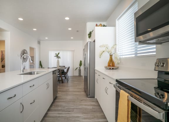 a kitchen with white cabinets and stainless steel appliances