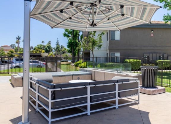 a patio with a bench and an umbrella