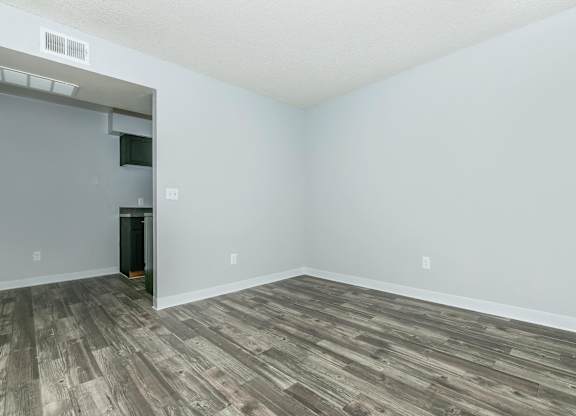 A room with a wooden floor and a white wall.