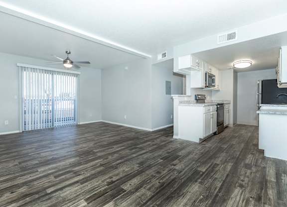 A room with wooden flooring and a ceiling fan.