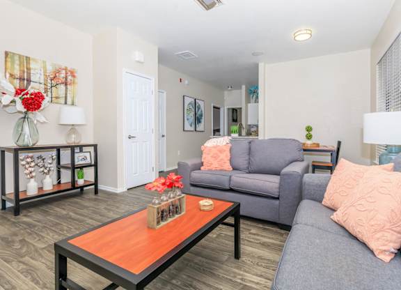 A living room with a grey couch and a wooden coffee table.