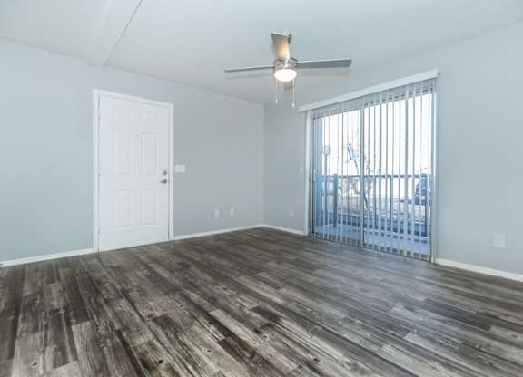A room with a sliding glass door and a ceiling fan.