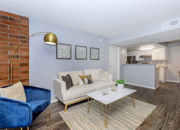 A living room with a blue chair and a white couch.
