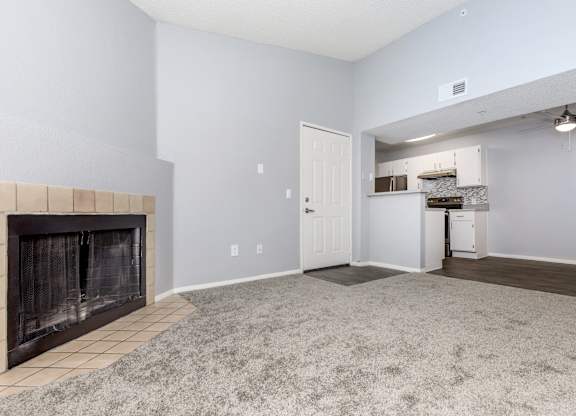 A living room with a fireplace and a carpeted floor.