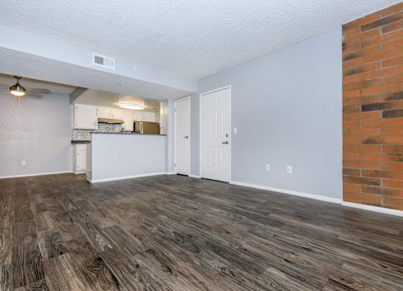 A room with wooden flooring and a brick wall.
