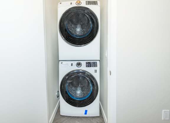 A white front loading washing machine with a blue label on the door.