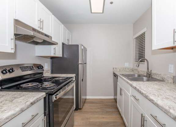 A kitchen with a black stove top oven and a black refrigerator.