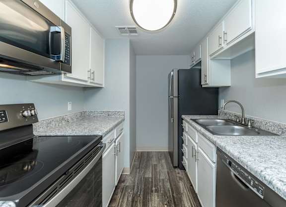A kitchen with a black fridge and a black stove.