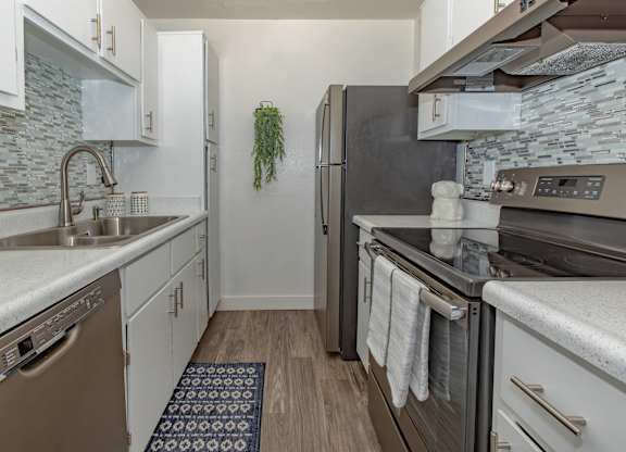 A kitchen with a black refrigerator and a white oven.