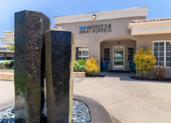 the front entrance with a stone water feature and a building