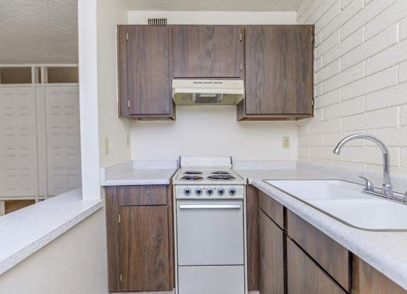 A kitchen with a white counter top and a white sink.