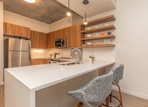 A kitchen with a white countertop and a stainless steel refrigerator.
