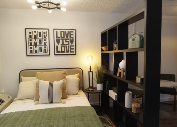 a bedroom with a bed and pictures on the wall