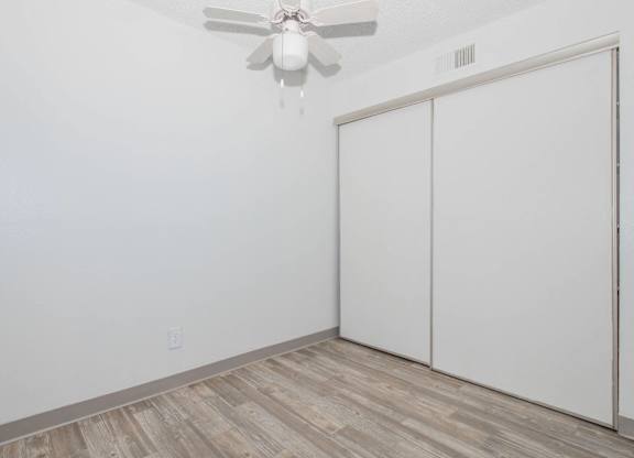A room with a ceiling fan and a sliding door.