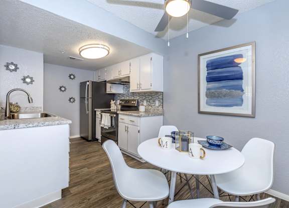 A kitchen with a table and chairs in the middle of the room.