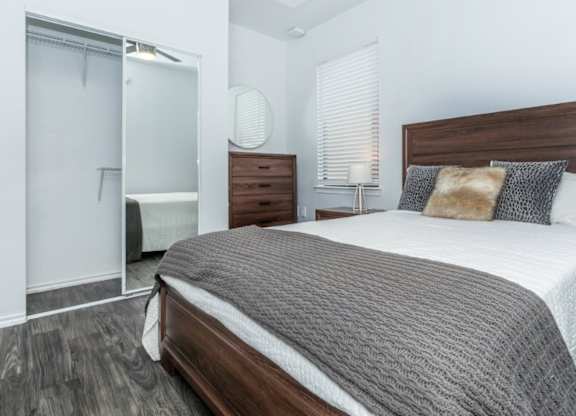 A bedroom with a large bed and a wooden headboard.