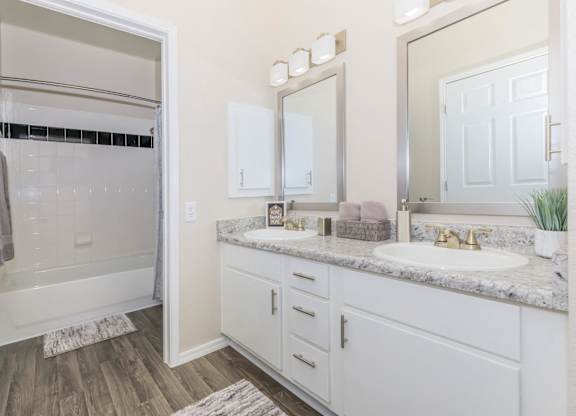 A bathroom with a white tub and sink.