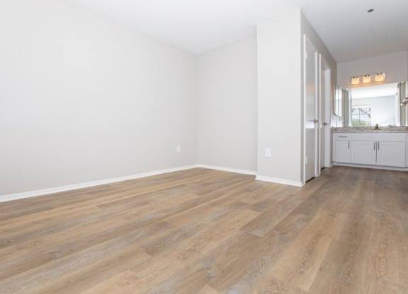 A room with wooden flooring and white walls.