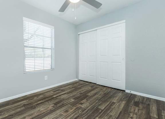 A room with a white door and a window with blinds.
