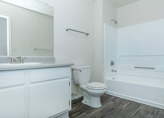 A white bathroom with a toilet, sink, and bathtub.