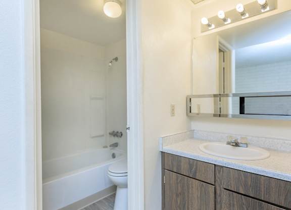 A white bathroom with a white tub and sink.