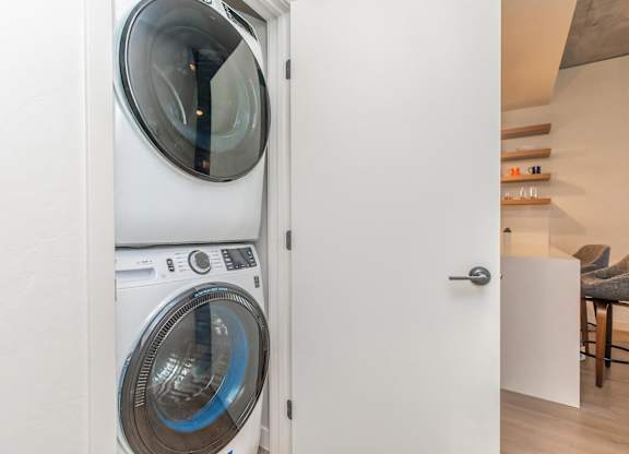 A white washing machine is in a doorway.