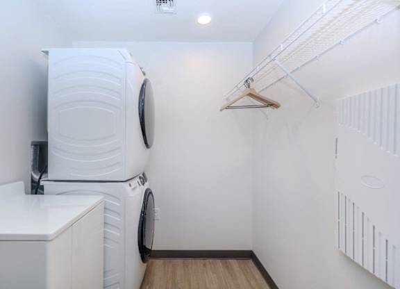 A white washing machine is in a small laundry room.