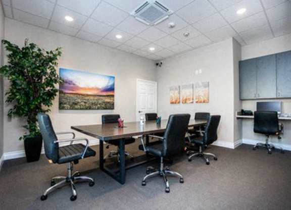 A conference room with a large table and chairs.