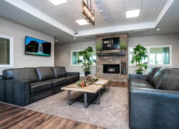 A living room with a fireplace and a flat screen TV mounted on the wall.
