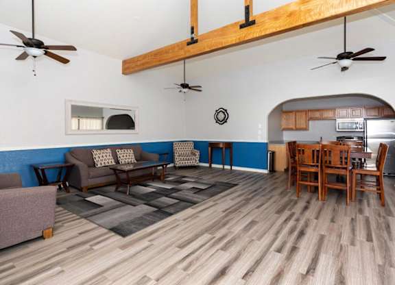 A living room with a couch, chairs, and a dining table.