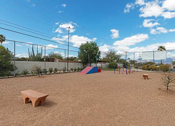 A playground with a red bench and a slide.