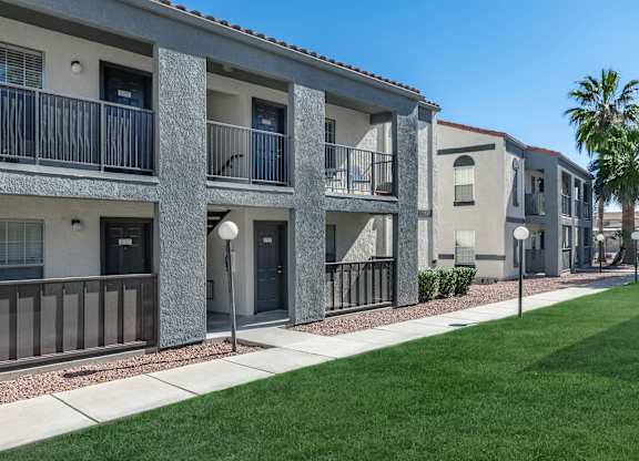 A row of modern apartment buildings with balconies and doors.
