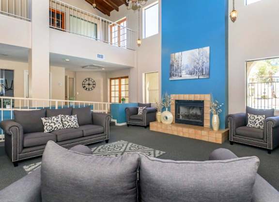 A living room with a grey couch and a fireplace.
