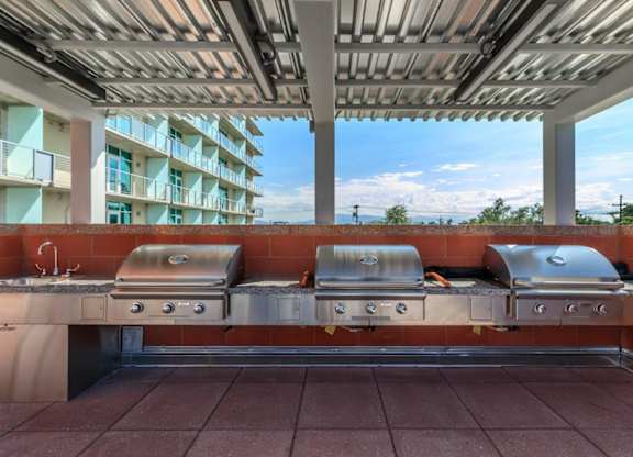 A row of grills are on a patio.