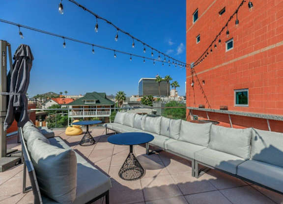 A patio with a table, chairs, and a string of lights.