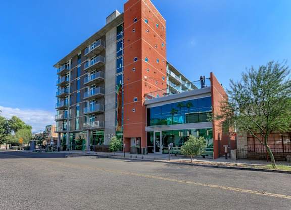 A large red building with a glass entrance and balconies.