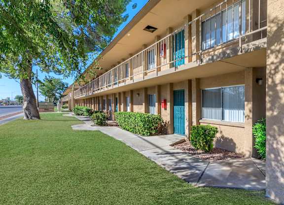 A row of apartment buildings with blue doors and windows.