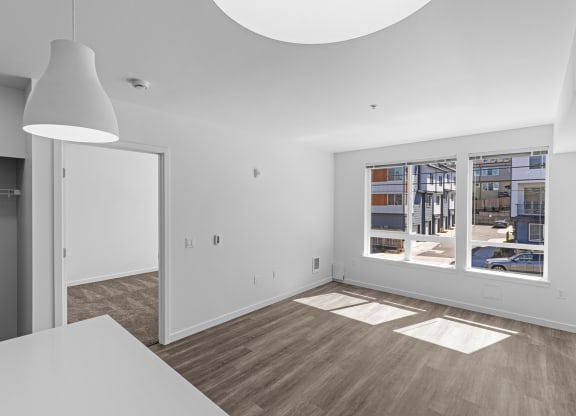 a living room and dining room with white walls and a large window