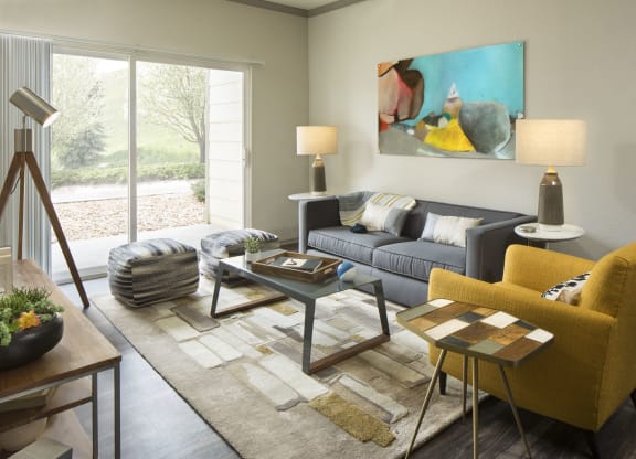 a living room with a gray couch and yellow chair