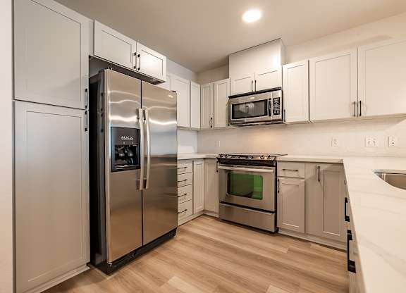 A modern kitchen with stainless steel appliances and white cabinets.