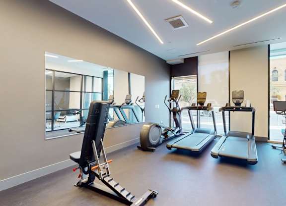 A spacious gym with treadmills, elliptical machines, and other exercise equipment.