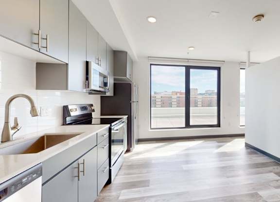 A modern kitchen with a view of the city through the window.