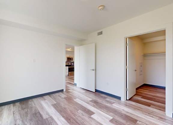 A room with a white wall and a wooden floor.