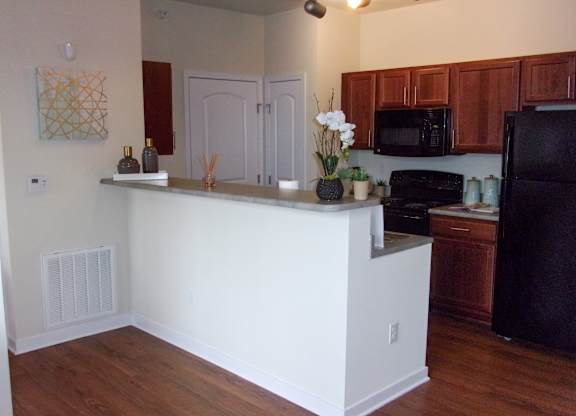 A kitchen with a white island and wooden cabinets.