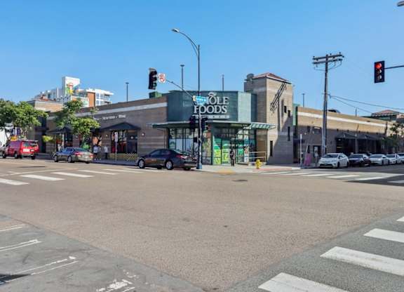 A street view with a traffic light showing red and a storefront with a green awning.