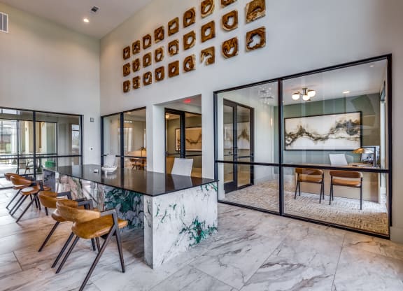 an open kitchen and dining room with a marble counter top and chairs