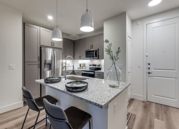an open kitchen with a marble counter top